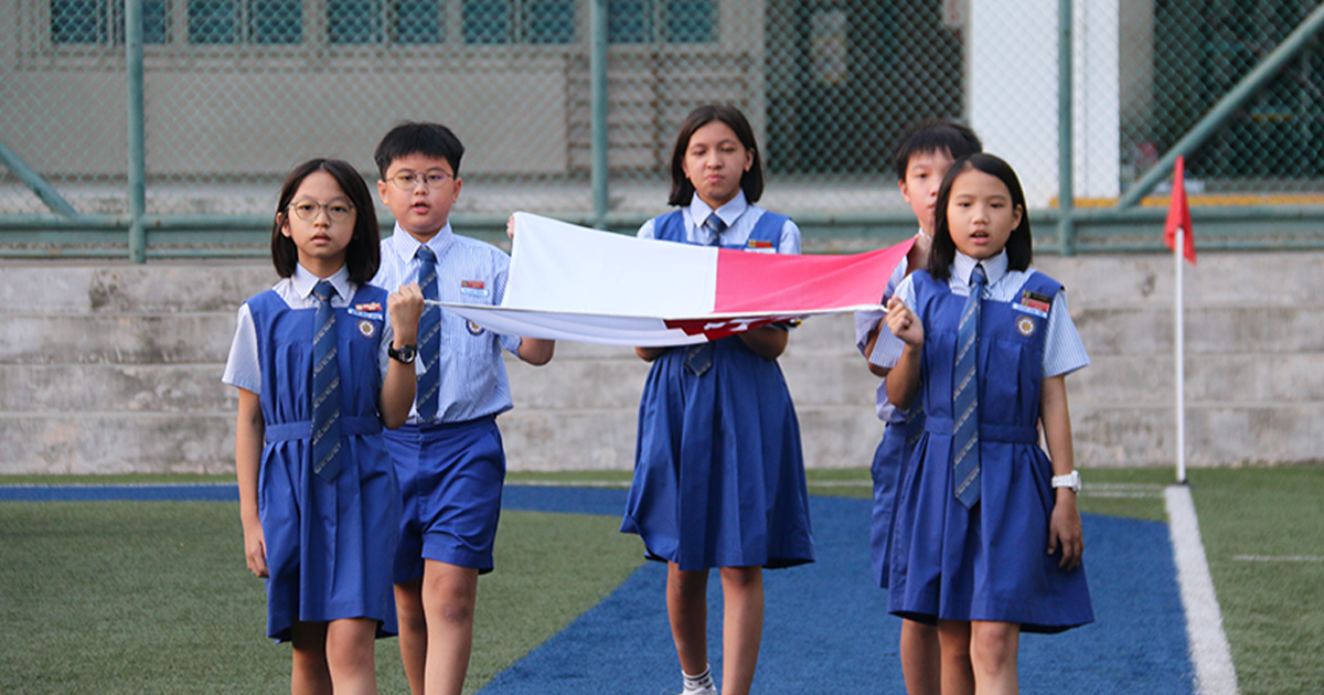 Students carrying the Singapore flag during the National Day Observance Ceremony.